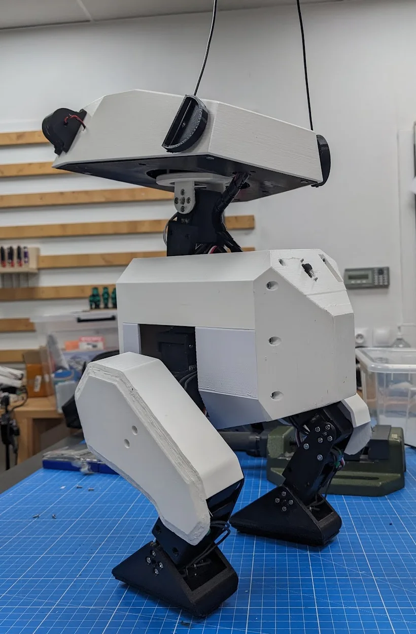 Side view of an assembled Open Duck Mini v2 showing its printed shell, legs, joints, and wiring